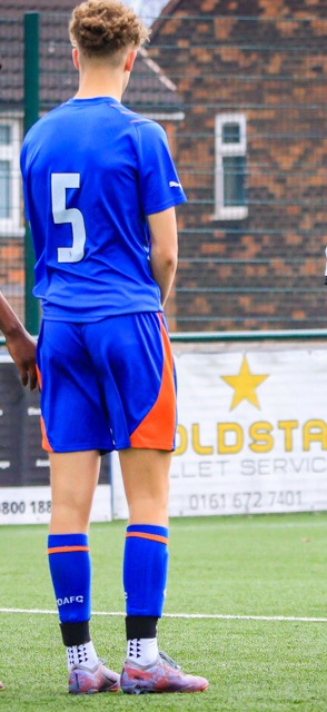 Back of an AR Elite player, number 5, standing anonymously in front of an Oldham hoarding